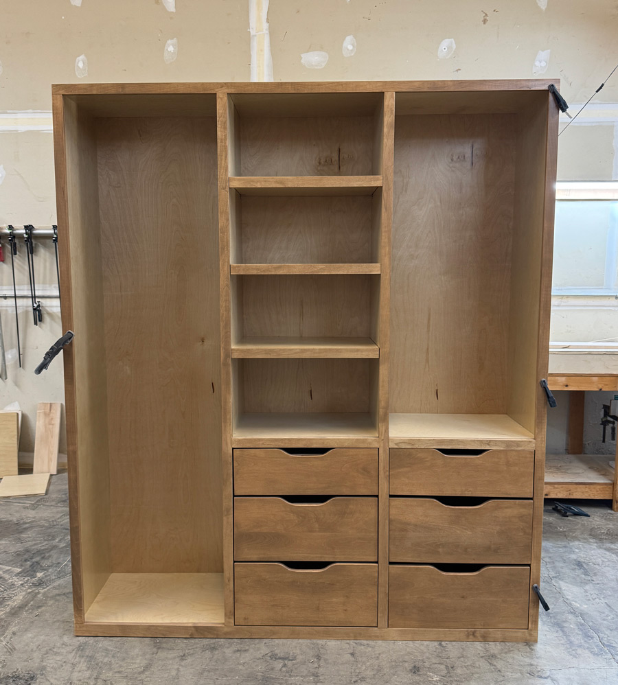 A custom built wooden shelf system with drawers.